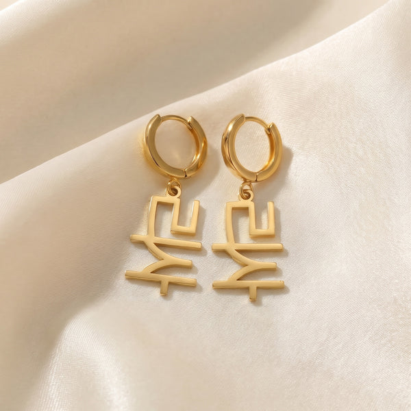 Pair of K-pop idol name drop earrings in Korean reading 리사 in 18K gold plating on ivory silk