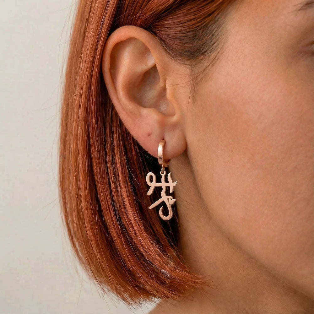 Personalized name drop earrings in Japanese in rose gold finish worn on ear, side profile view