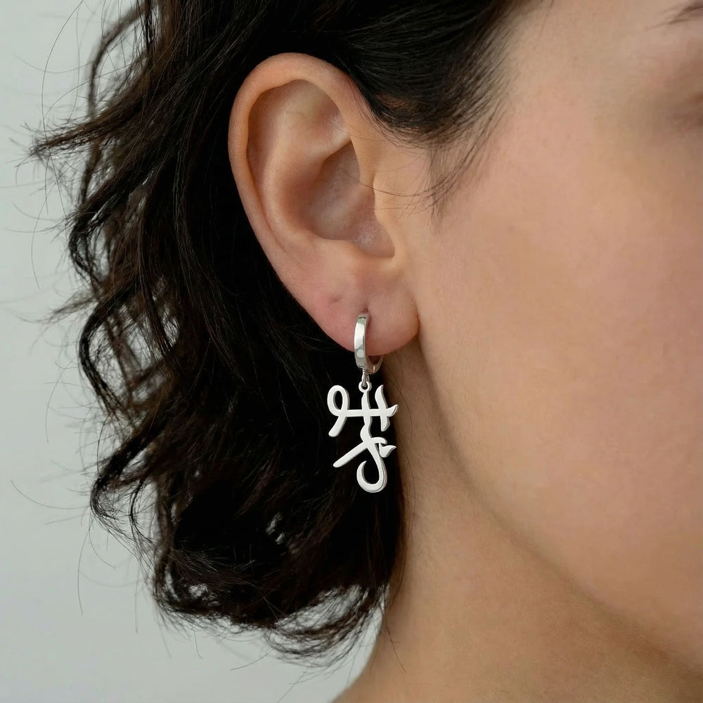Personalized name drop earrings in Japanese in silver finish worn on ear, side profile view