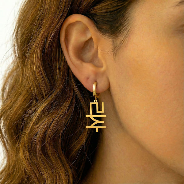 Personalized name drop earrings in Korean in gold finish worn on ear, side profile view
