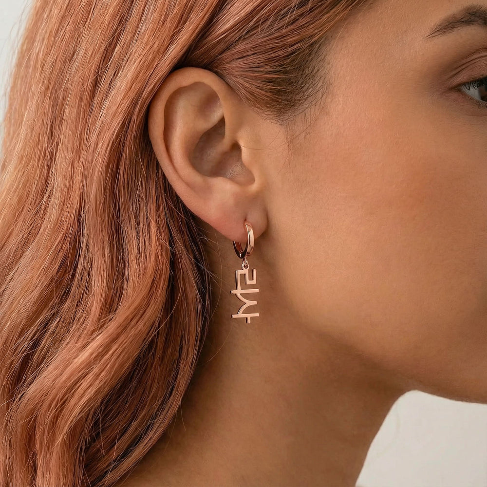Personalized name drop earrings in Korean in rose gold finish worn on ear, side profile view