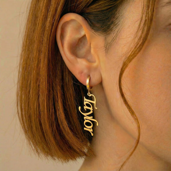 Personalized name drop earrings in gold finish worn on ear, side profile view