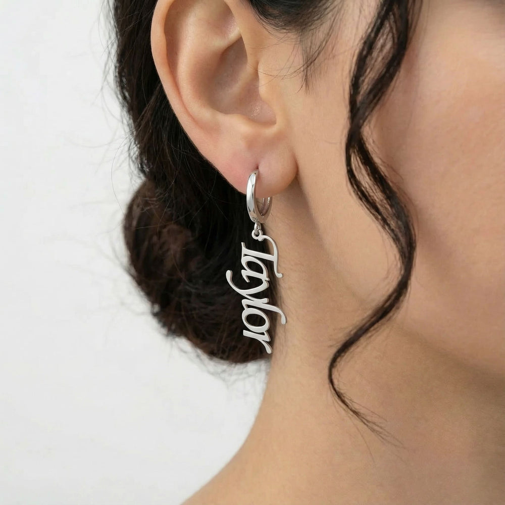 Personalized name drop earrings in silver finish worn on ear, side profile view