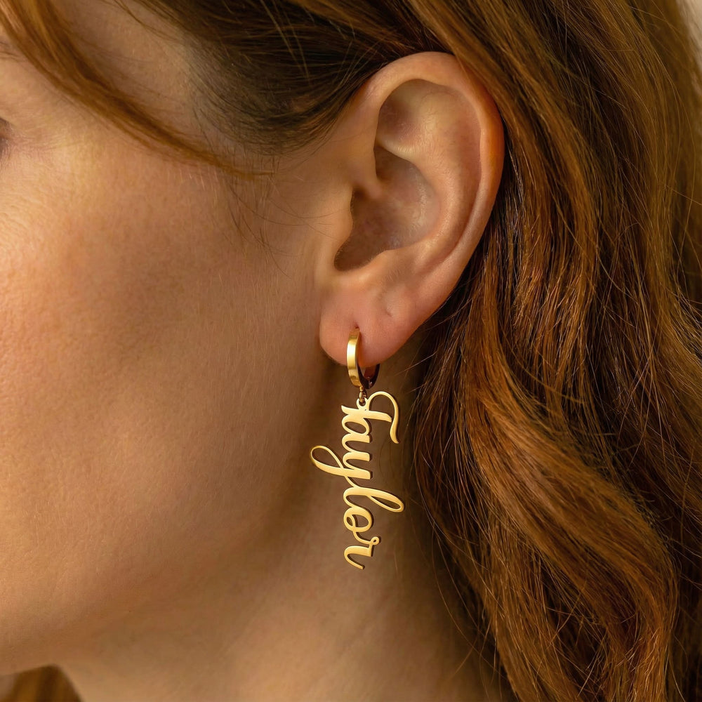 Personalized name drop earrings in gold finish worn on ear, side profile view