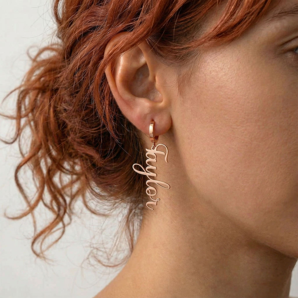 Personalized name drop earrings in rose gold finish worn on ear, side profile view