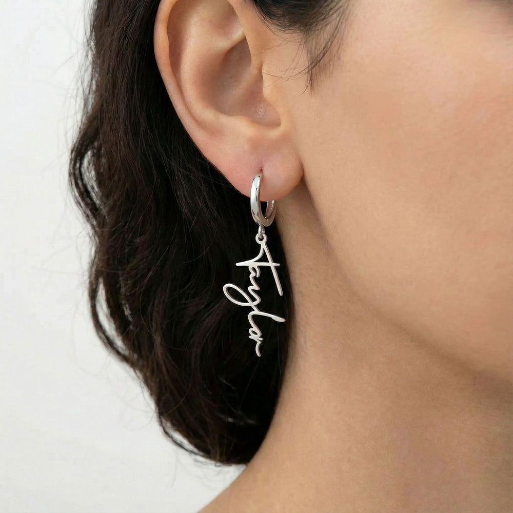 Personalized name drop earrings in silver finish worn on ear, side profile view