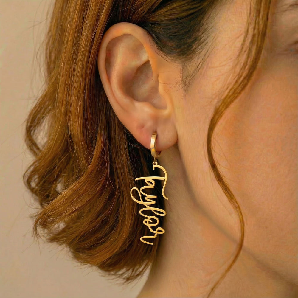 Personalized name drop earrings in gold finish worn on ear, side profile view