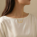 Gold Arabic script name necklace reading ليلى worn on woman’s neck in lifestyle photo