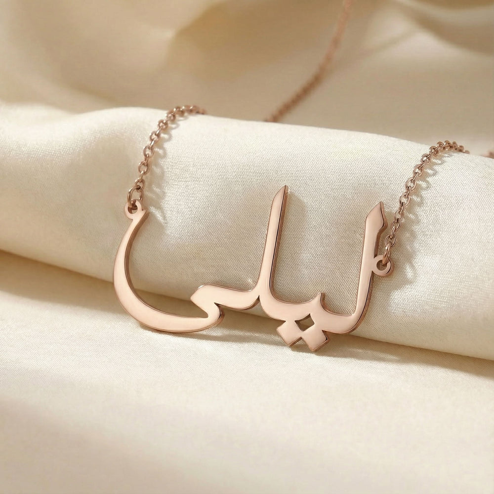 Personalized name necklace in Arabic in rose gold finish on beige silk fabric