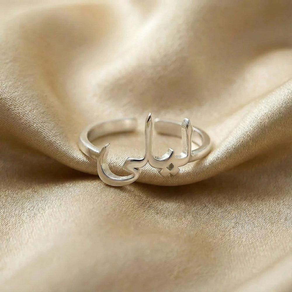 Personalized name ring in Arabic, one-size in silver finish on beige silk fabric