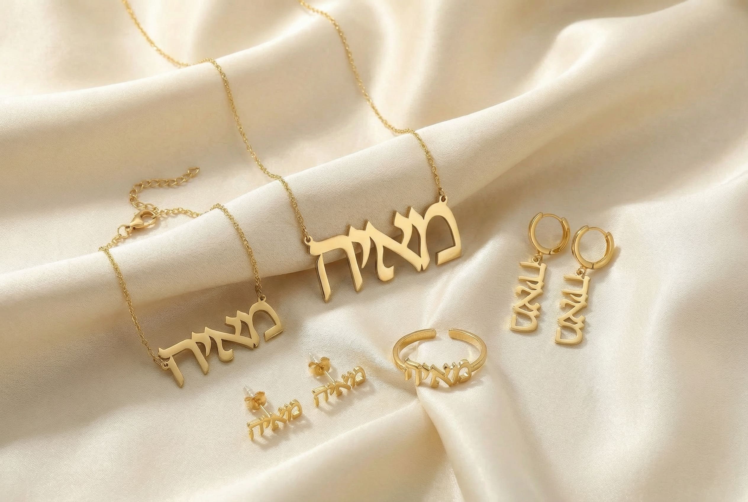 Gold Hebrew jewelry set including necklaces, earrings, and rings on a silk beige silk