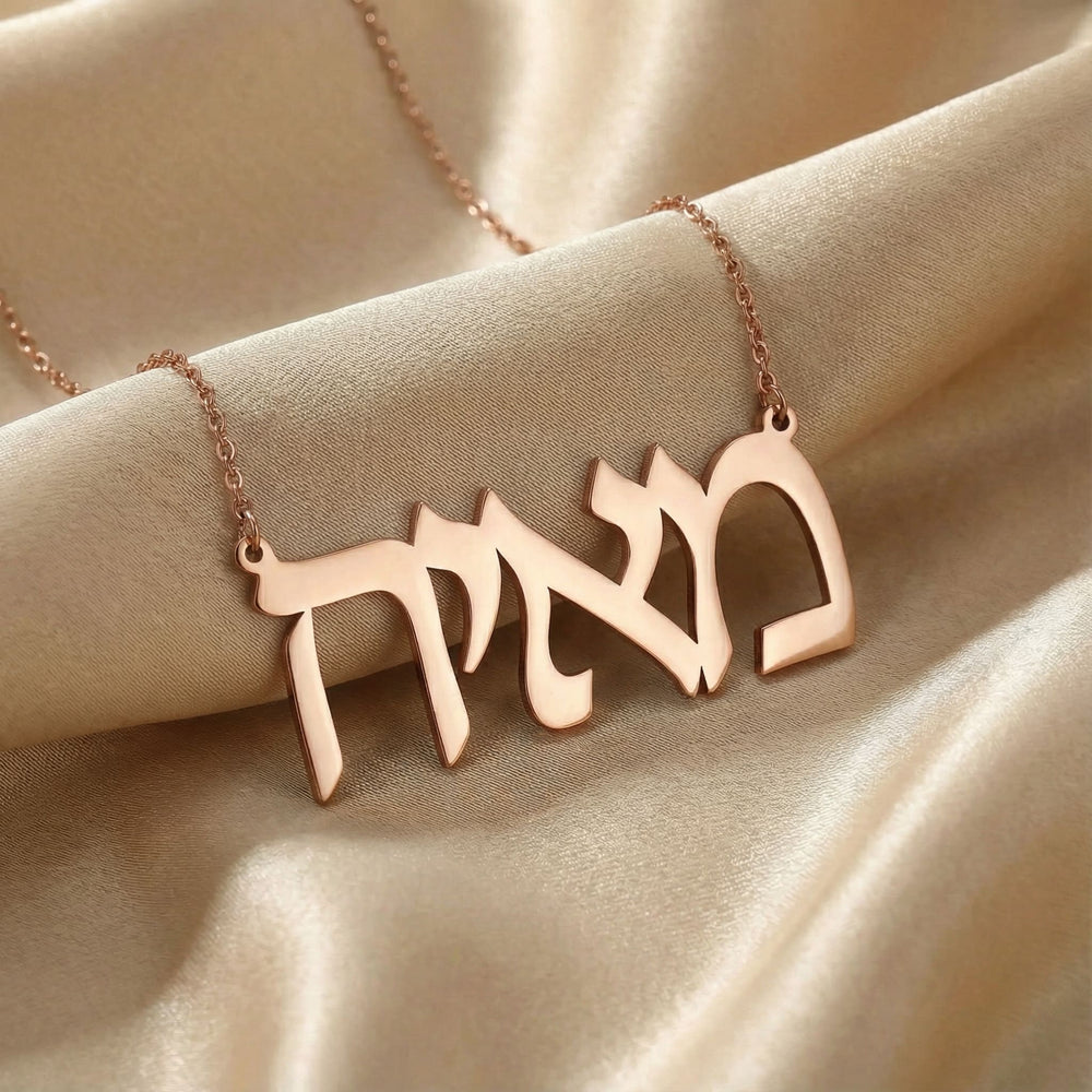 Personalized name necklace in Hebrew in rose gold finish on beige silk fabric