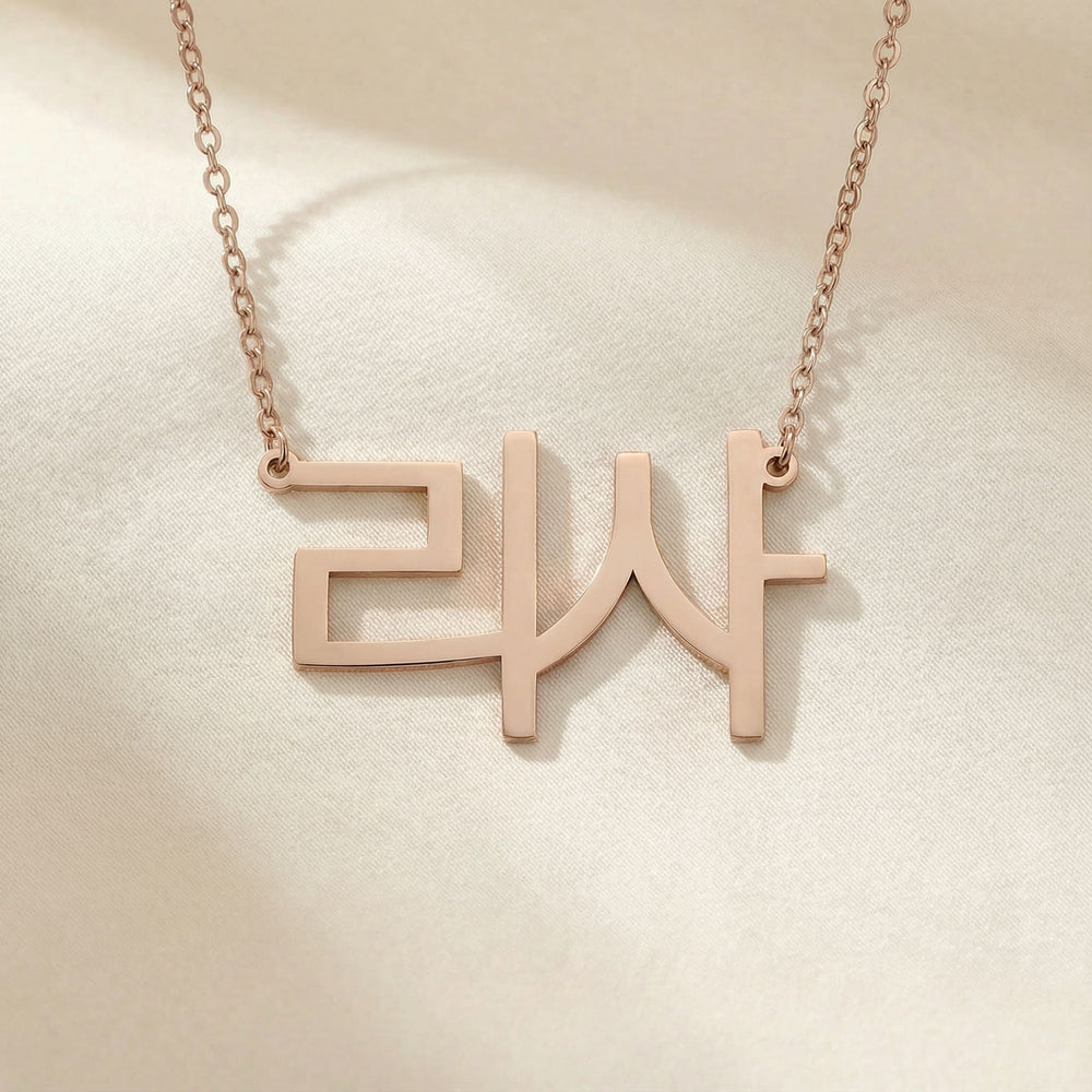 Personalized name necklace in Korean in rose gold finish on beige silk fabric