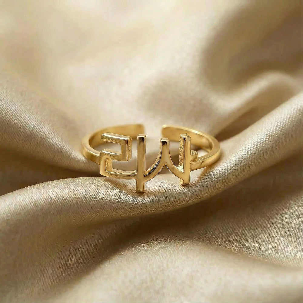 Personalized name ring in Korean, one-size in gold finish on beige silk fabric