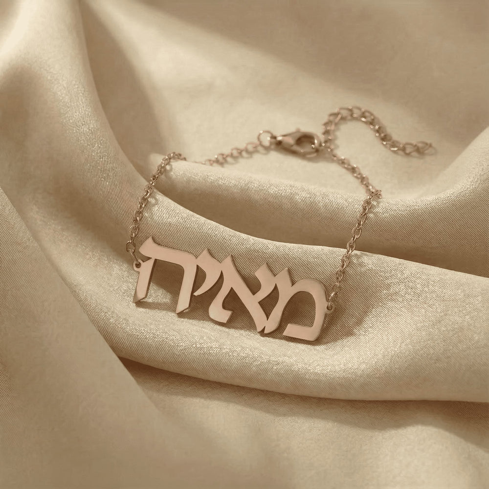 Personalized name bracelet in Hebrew in rose gold finish on beige silk fabric