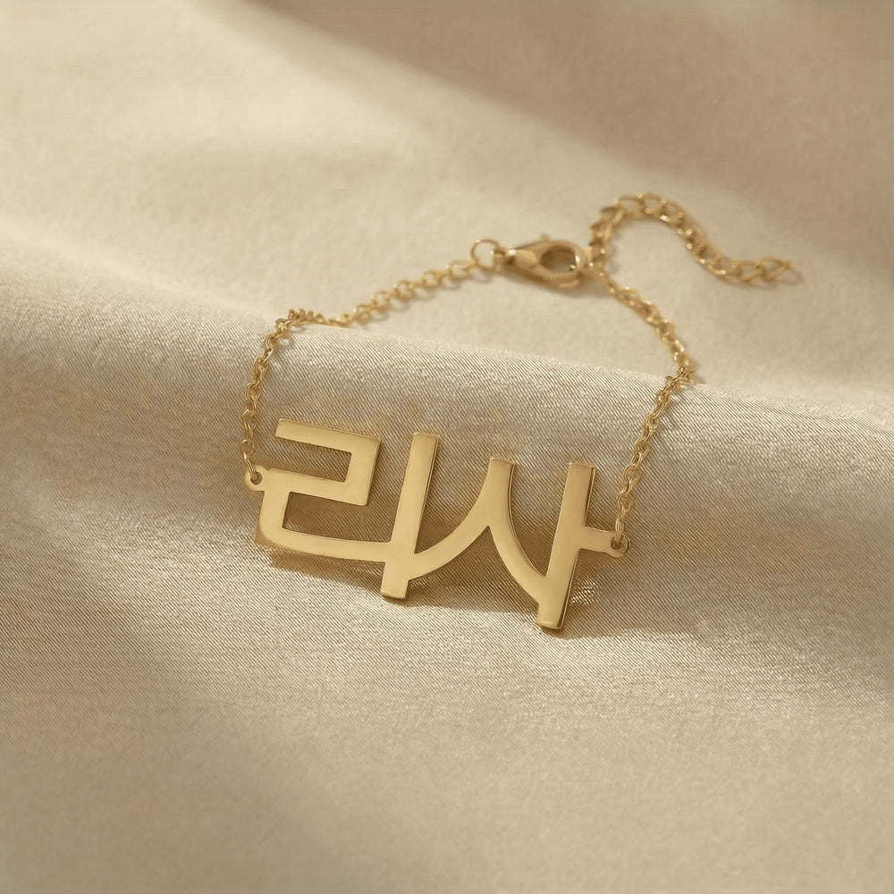 Personalized name bracelet in Korean in gold finish on beige silk fabric