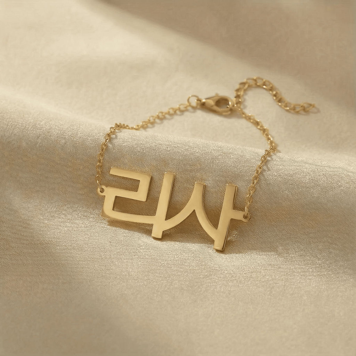Personalized name bracelet in Korean in gold finish on beige silk fabric