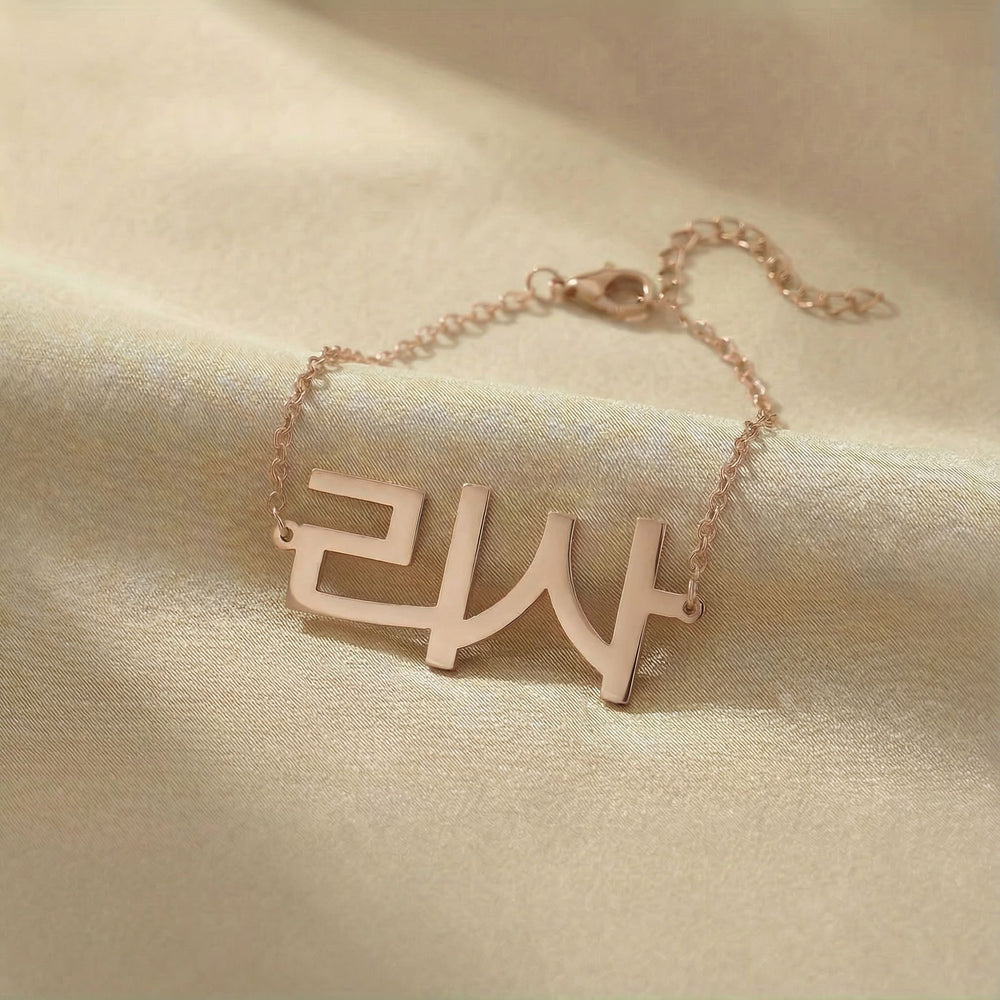 Personalized name bracelet in Korean in rose gold finish on beige silk fabric