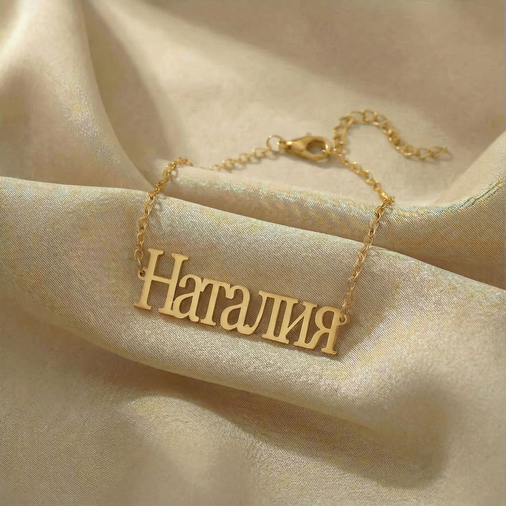 Personalized name bracelet in Cyrillic in gold finish on beige silk fabric