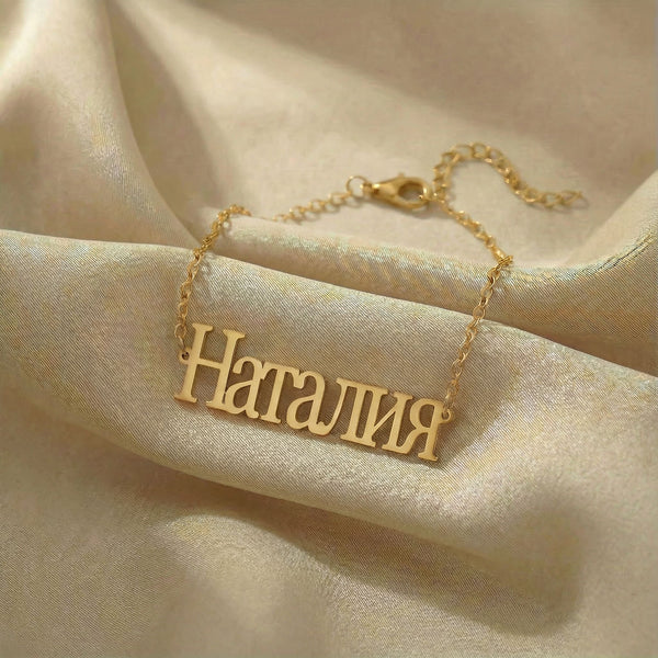 Personalized name bracelet in Cyrillic in gold finish on beige silk fabric