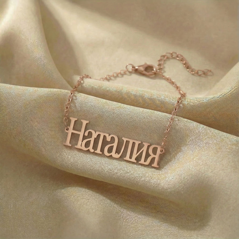 Personalized name bracelet in Cyrillic in rose gold finish on beige silk fabric