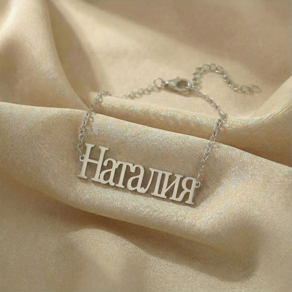 Personalized name bracelet in Cyrillic in silver finish on beige silk fabric