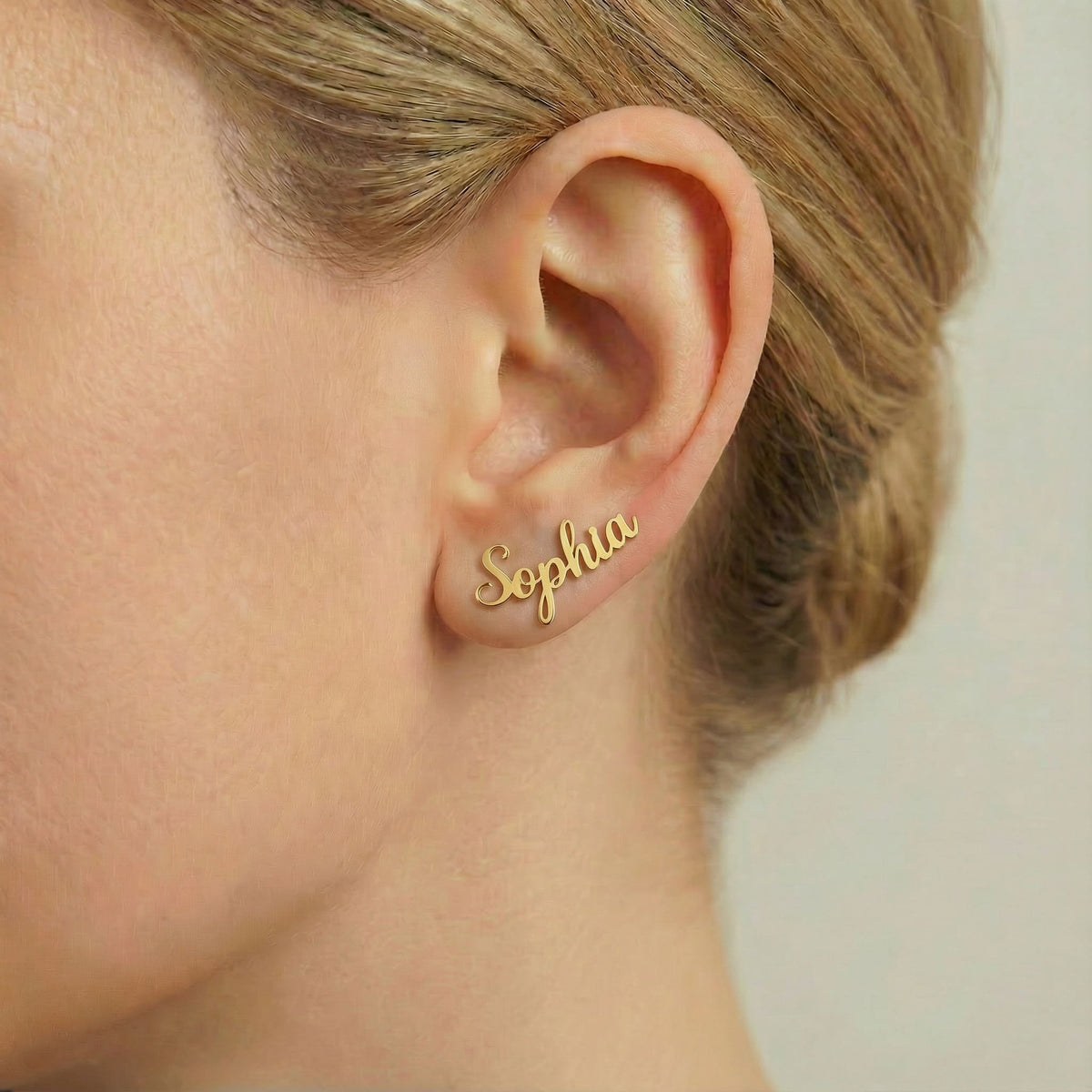 Personalized name ear climber earrings in gold finish worn on ear, side profile view