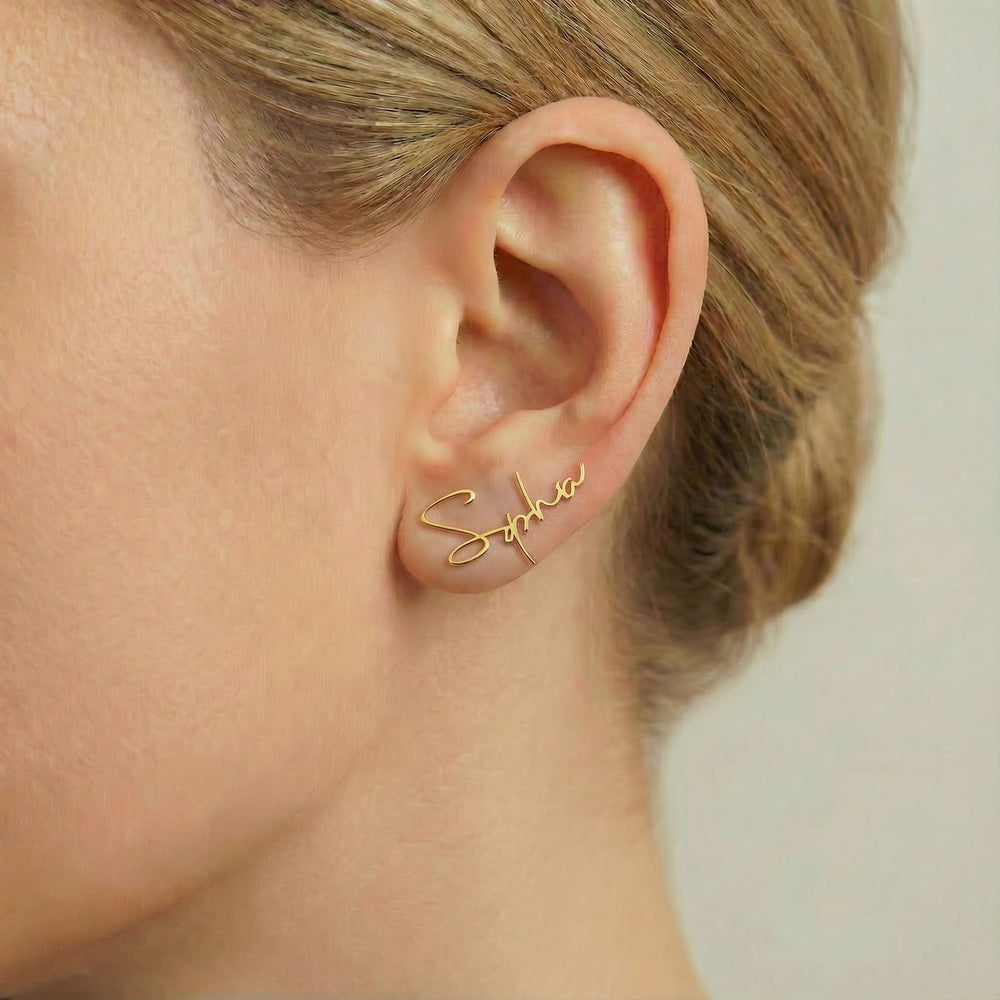 Personalized name ear climber earrings in gold finish worn on ear, side profile view