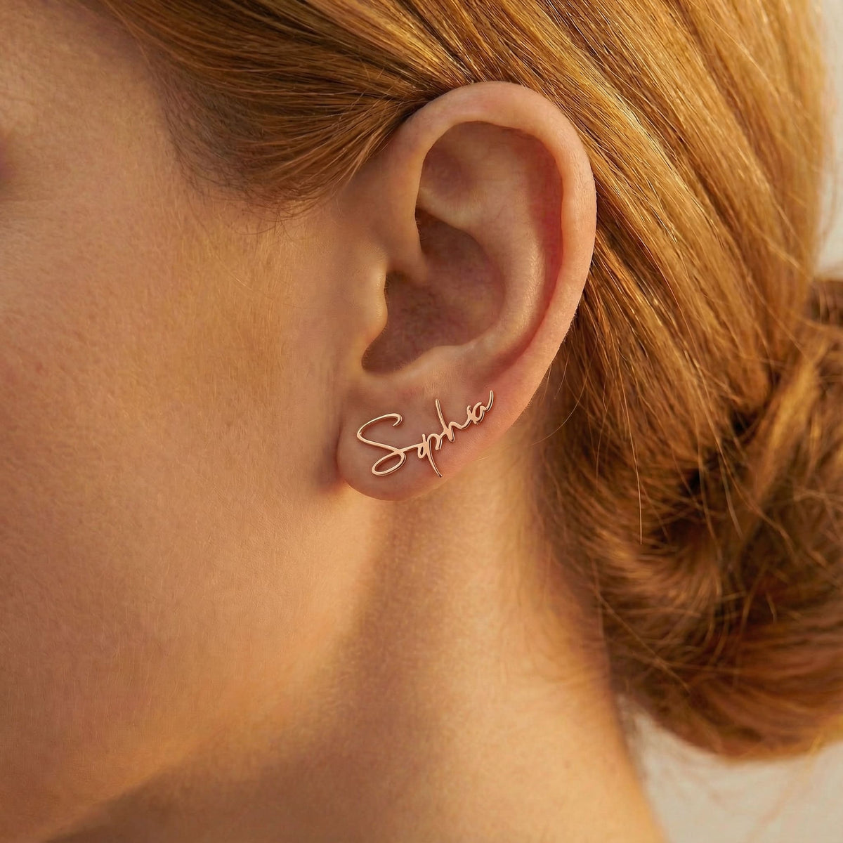 Personalized name ear climber earrings in rose gold finish worn on ear, side profile view