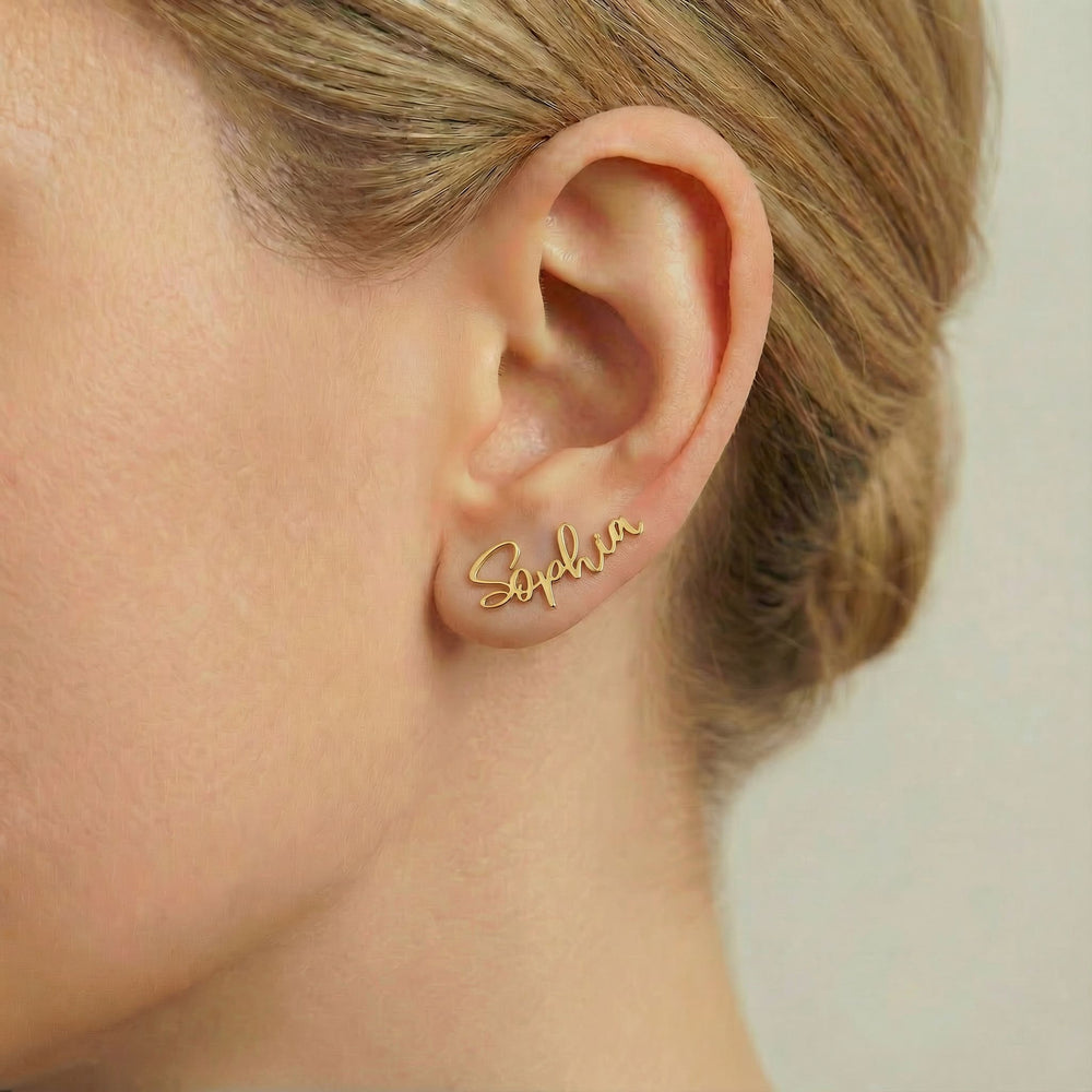 Personalized name ear climber earrings in gold finish worn on ear, side profile view