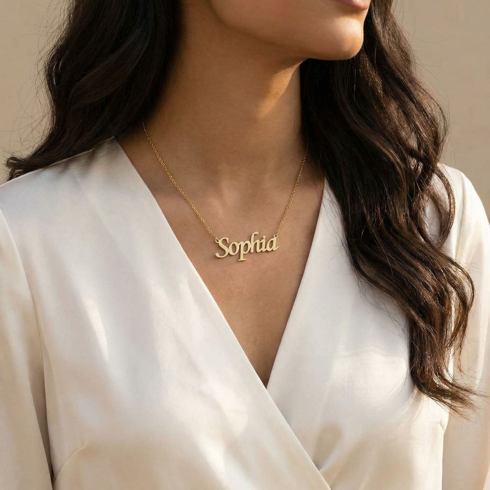 Gold Latin script name necklace reading Sophia worn on woman’s neck in elegant lifestyle shot