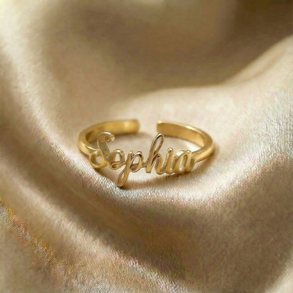 Personalized name ring, one-size in gold finish on beige silk fabric