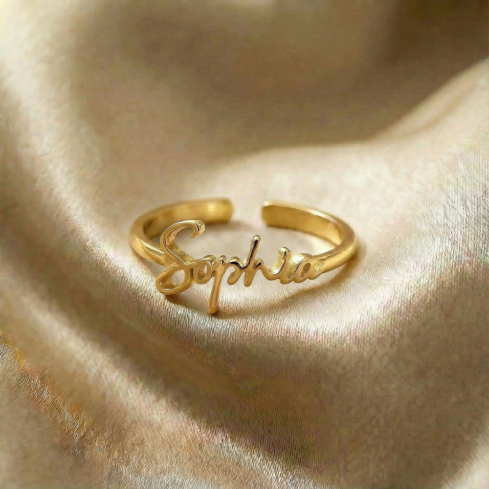 Personalized name ring, one-size in gold finish on beige silk fabric