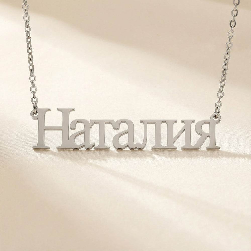 Personalized name necklace in Cyrillic in silver finish on beige silk fabric