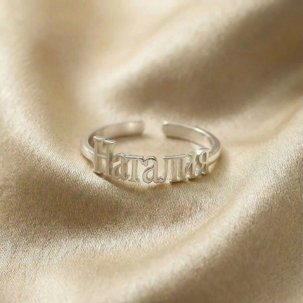 Personalized name ring in Cyrillic, one-size in silver finish on beige silk fabric