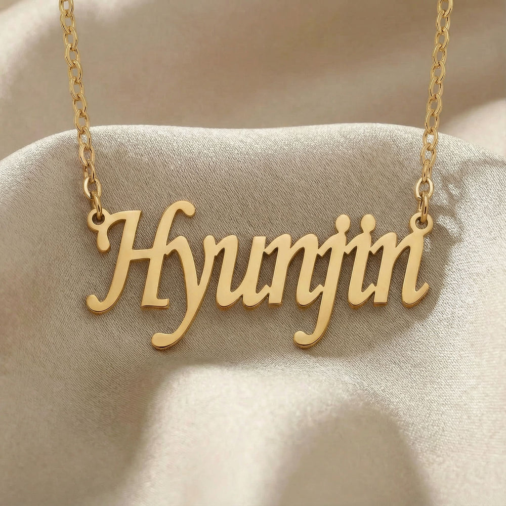 Personalized name necklace in gold finish on beige silk fabric