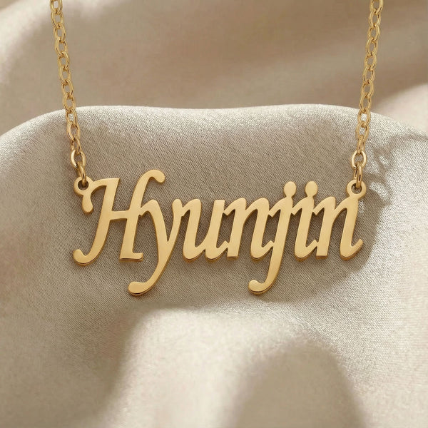 Personalized name necklace in gold finish on beige silk fabric