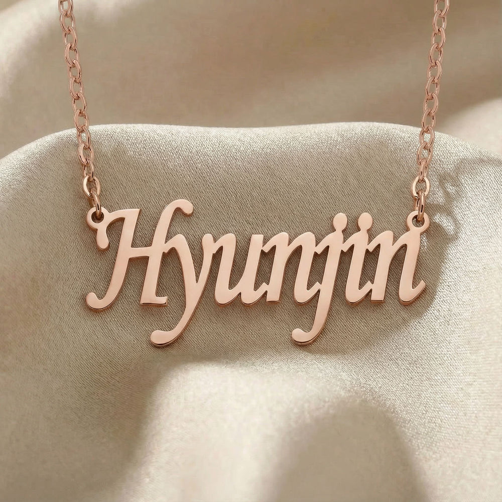 Personalized name necklace in rose gold finish on beige silk fabric