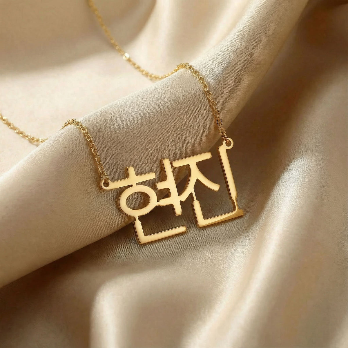 Personalized name necklace in Korean in gold finish on beige silk fabric