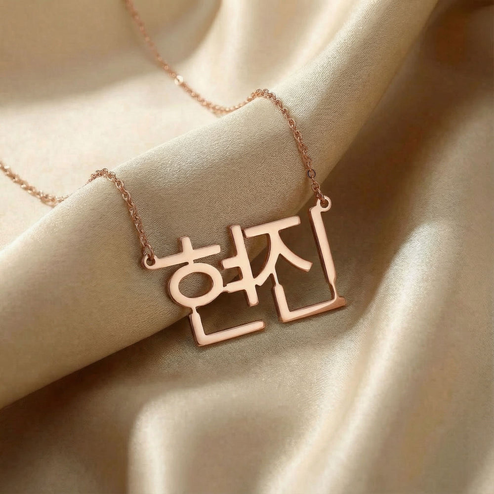 Personalized name necklace in Korean in rose gold finish on beige silk fabric