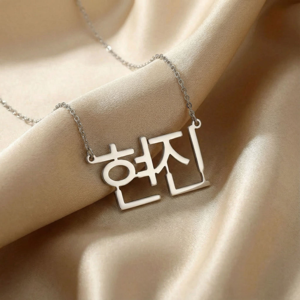Personalized name necklace in Korean in silver finish on beige silk fabric