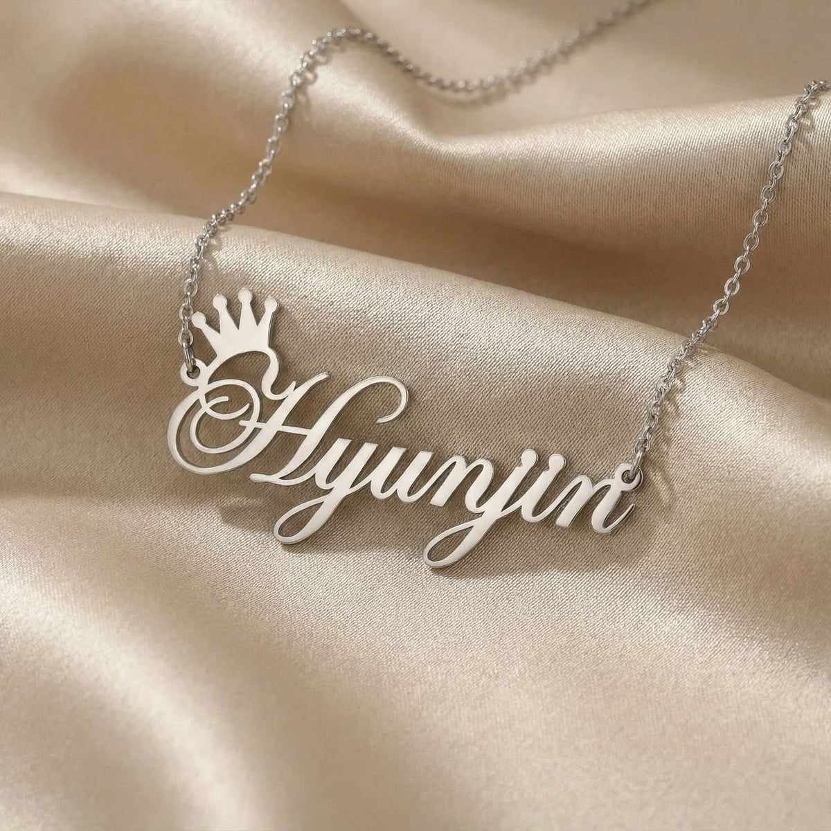 Personalized name necklace in silver finish on beige silk fabric