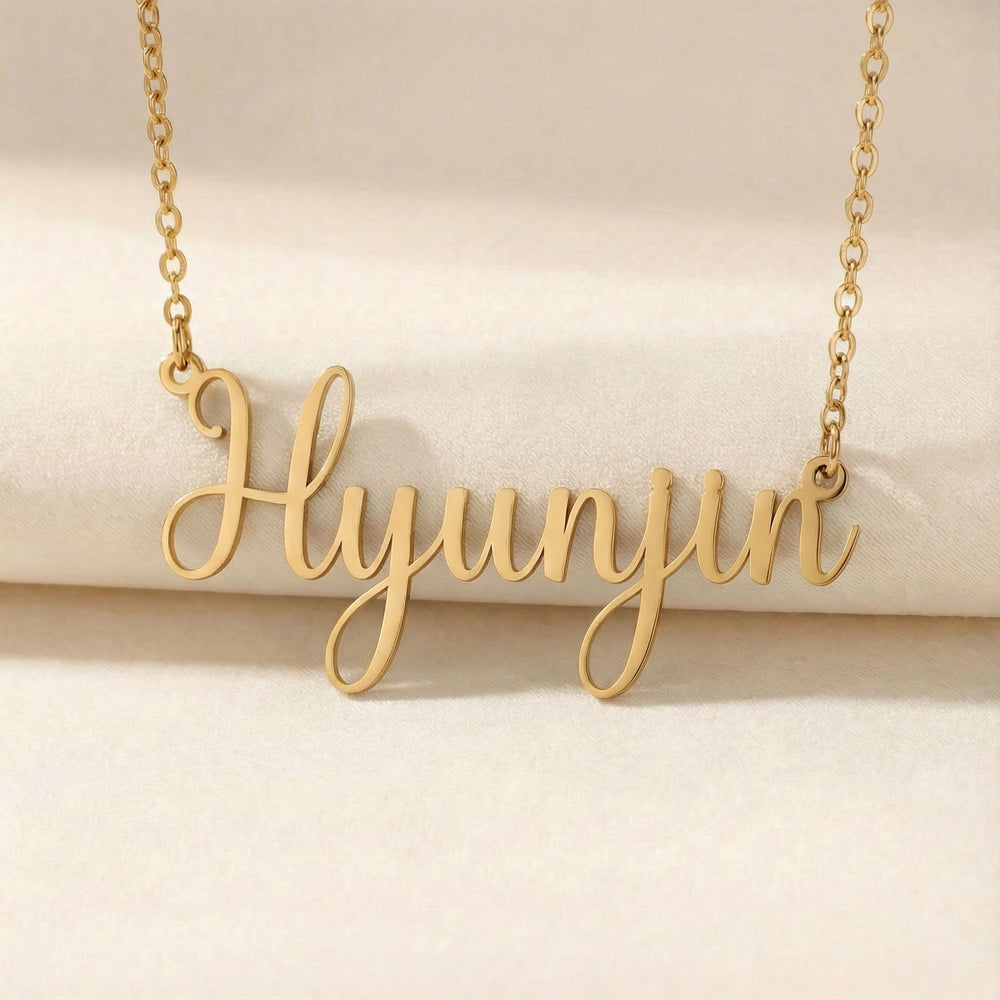 Personalized name necklace in gold finish on beige silk fabric