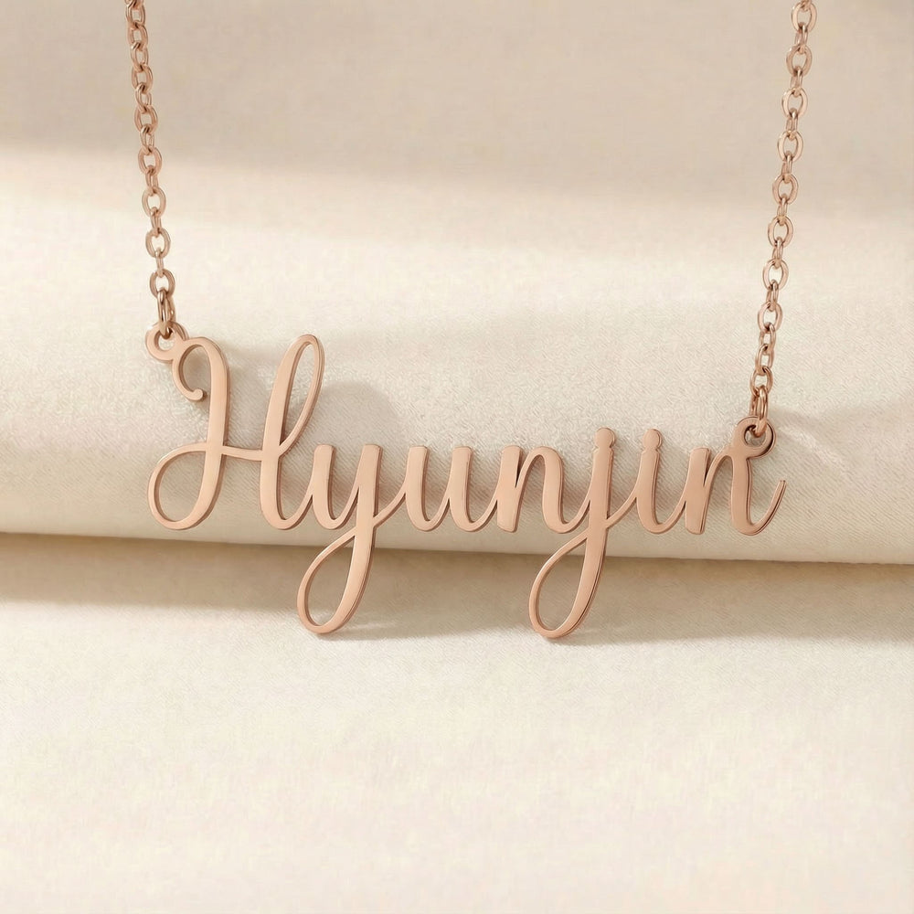 Personalized name necklace in rose gold finish on beige silk fabric