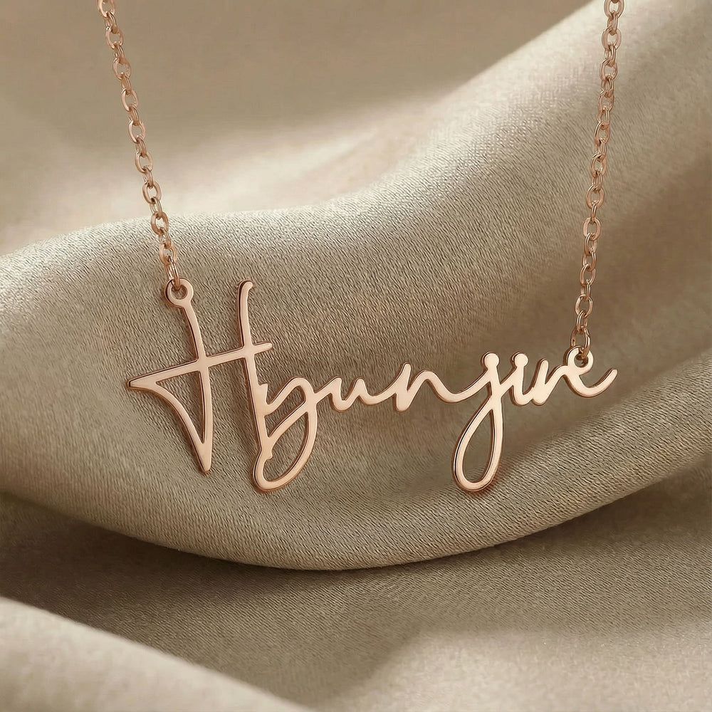Personalized name necklace in rose gold finish on beige silk fabric