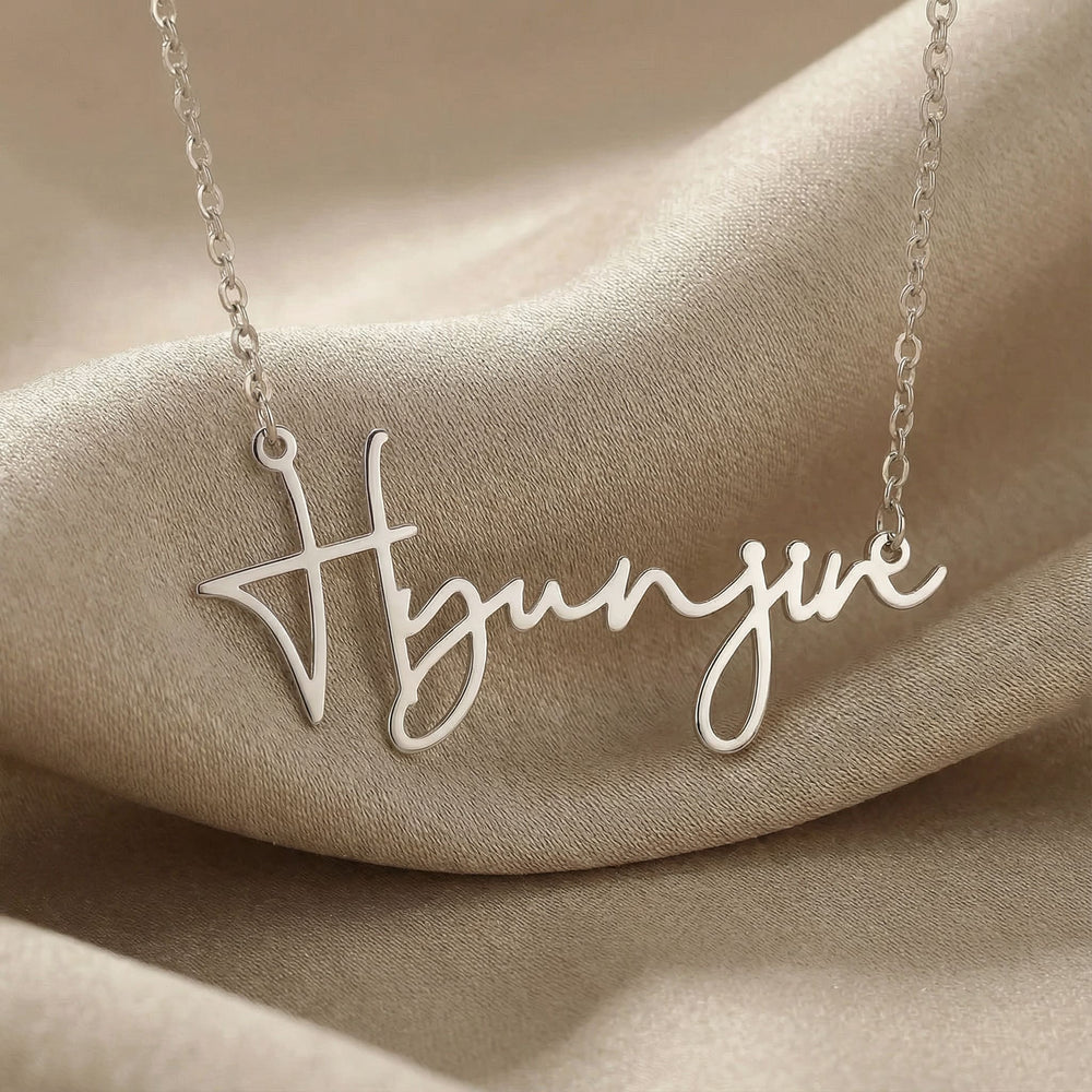 Personalized name necklace in silver finish on beige silk fabric