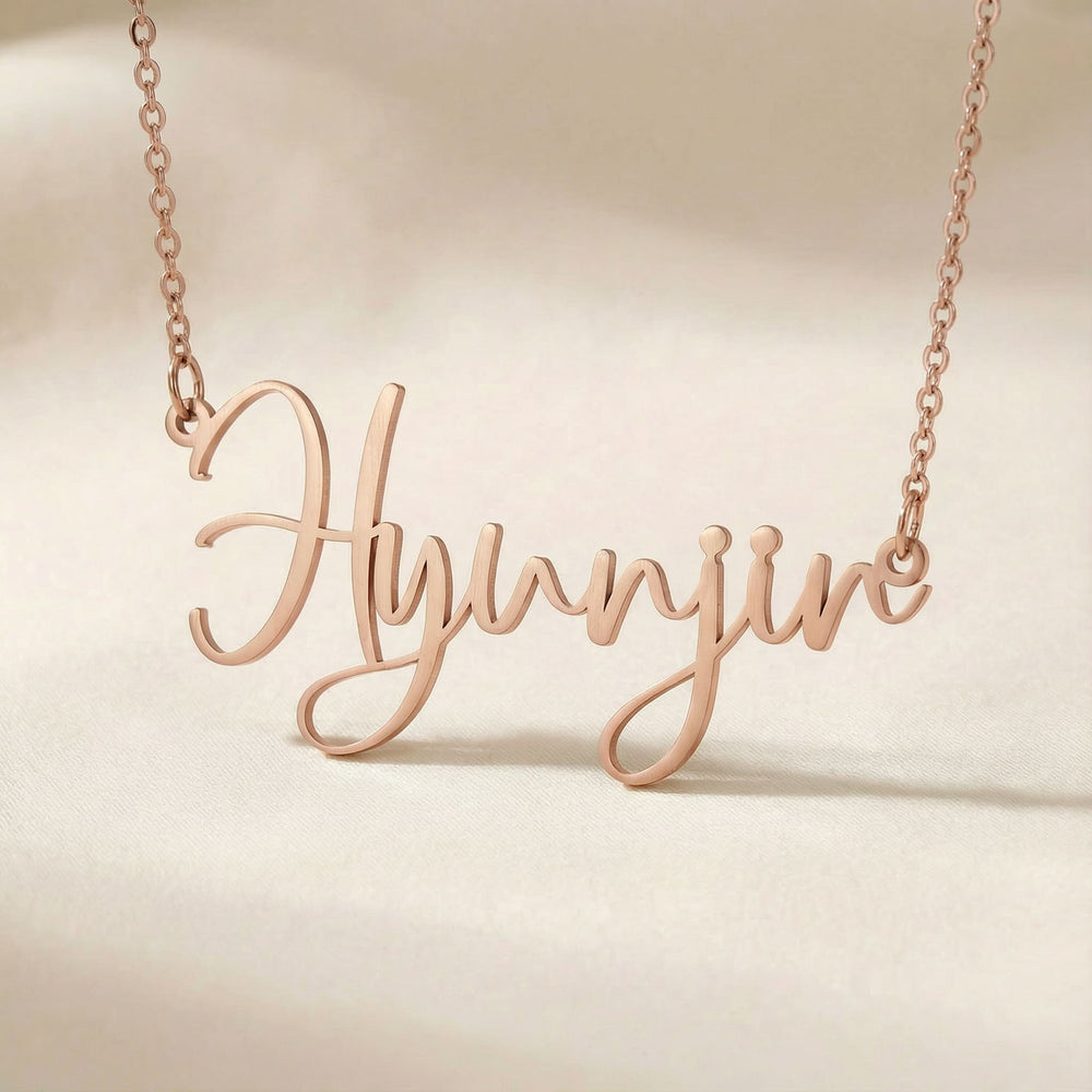 Personalized name necklace in rose gold finish on beige silk fabric