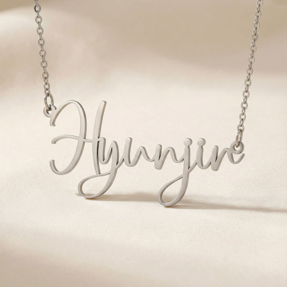 Personalized name necklace in silver finish on beige silk fabric
