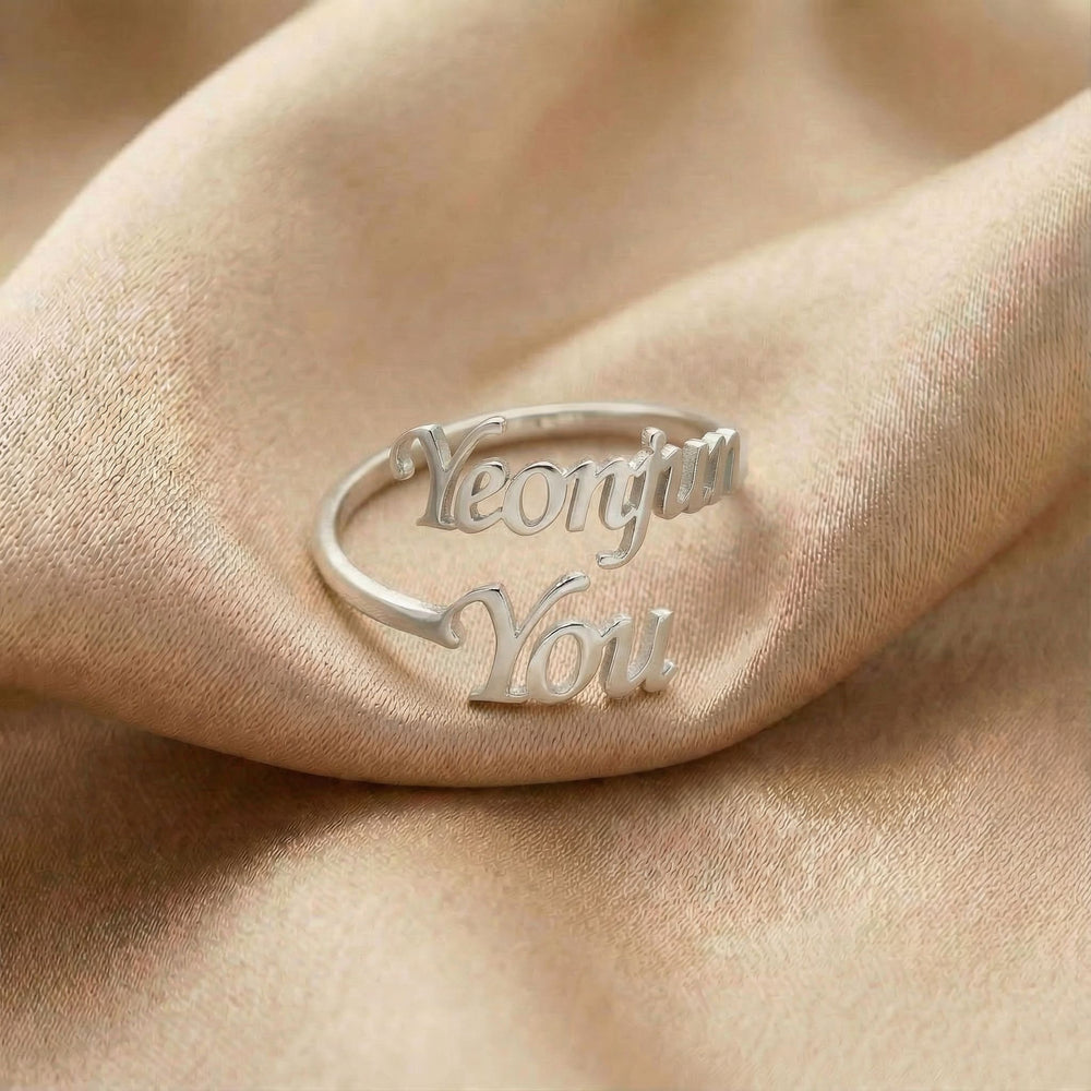 Personalized name ring, one-size in silver finish on beige silk fabric