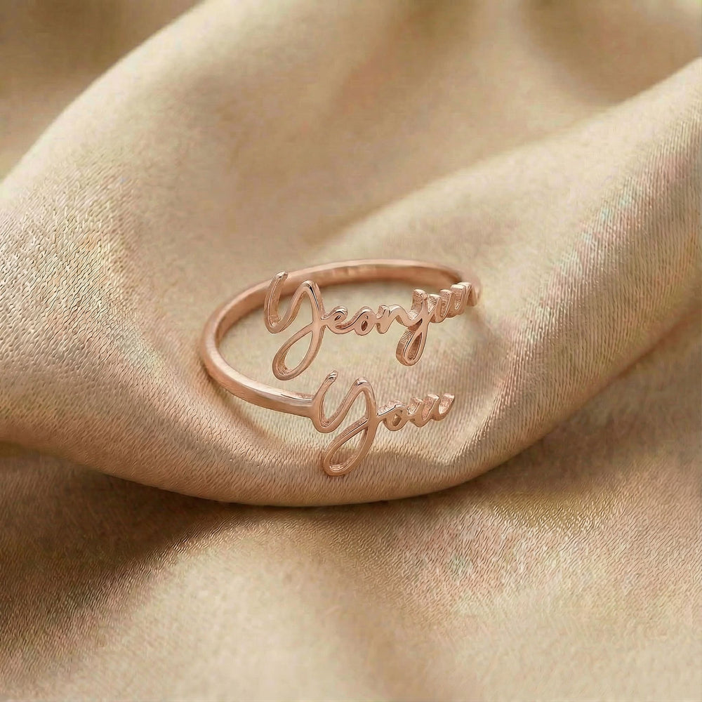 Personalized name ring, one-size in rose gold finish on beige silk fabric